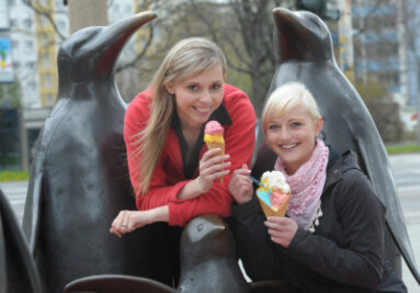 Sindy Wohlgemuth und Monique Erler (von links) lassen sich an der Seite der Chemnitzer Pinguine ihr Eis schmecken. Ihre Wahl fiel auf fruchtiges Mango- und Himbeereis aus der Bellini-Produktion. 