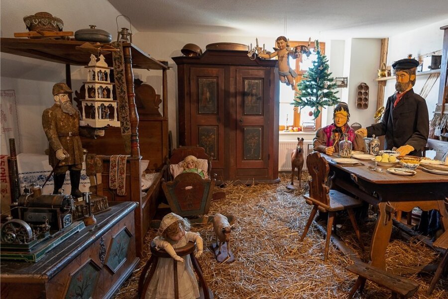 Auf den Dielen der vogtländischen Bauernstube im Heimatmuseum Falkenstein liegt zur Weihnachtsschau Stroh, der Weihnachtsbaum hängt an der Decke und das Neunerlei steht auf dem Tisch.