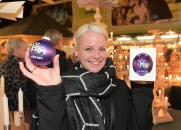 So sieht die neue FCE-Weihnachtskugel aus - Besucherin Romy Lorenz aus Oelsnitz hält die neue FCE-Weihnachtskugel in Händen. 