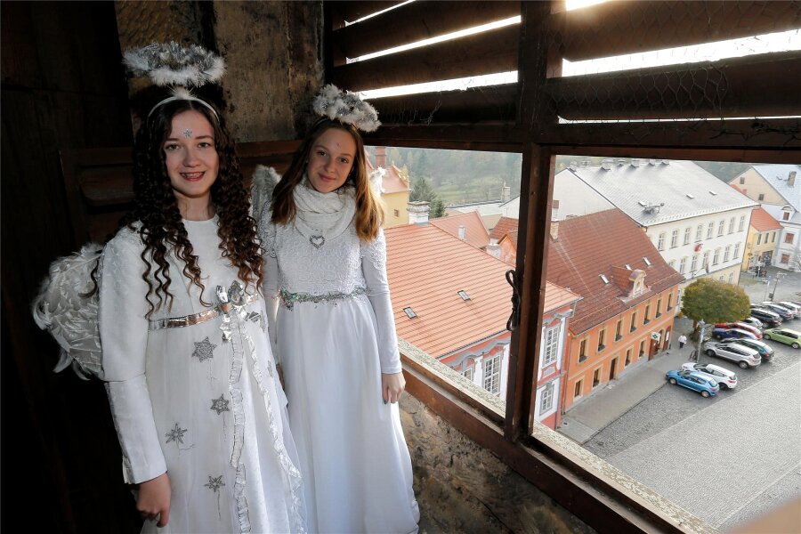 So wird auf der tschechischen Seite des Erzgebirges Weihnachten gefeiert - mit Engel und Goldschwein - Zwei Engel auf dem Kirchturm in Úštěk, an Seilen schweben sie später auf den Markt hinunter.