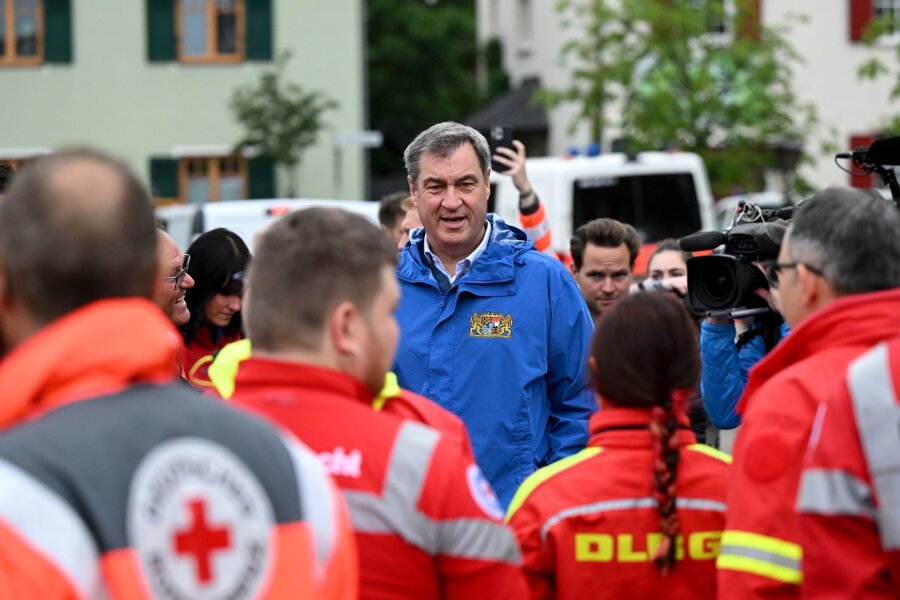 Söder: 100 Millionen Euro "plus X" für Flut-Hilfe - Bayerns Ministerpräsident Markus Söder (M, CSU), spricht zu Einsatzkräften vom Roten Kreuz, DLRG und anderen Rettungskräften bei einer Ortsbesichtigung im vom Hochwasser betroffenen oberbayerischen Reichertshofen.