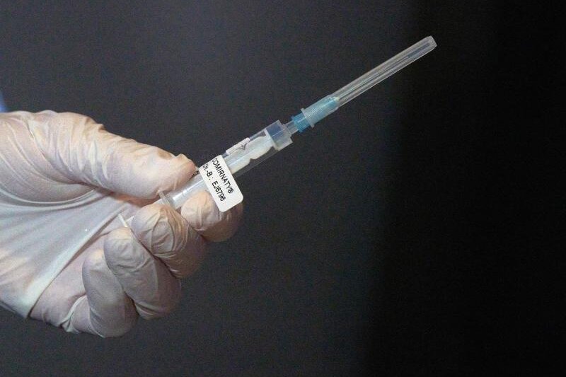            Eine Mitarbeiterin des Impfteams überprüft eine Spritze.