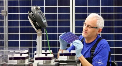 Solarworld zieht Teile der Produktion aus Freiberg ab - Ein Solarworld-Mitarbeiter der Modulfertigung prüft eine Solarzelle. Die Zellen werden in den Solarmodulen verbaut. Künftig soll die Produktion der Zellen in Arnstadt konzentriert werden.