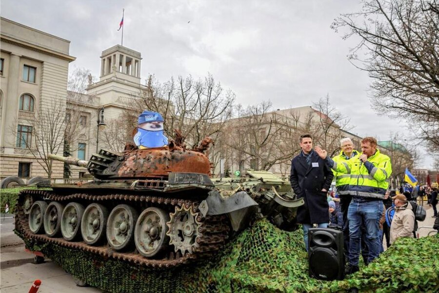 Solidaritätsschwur und ein Panzerwrack - Als "Symbol des Untergangs" verstehen die Initiatoren den zerstörten russischen Kampfpanzer, den sie vor der russischen Botschaft in Berlin aufgestellt haben. 