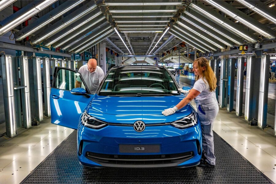 Sonderaktion von Volkswagen treibt Nachfrage nach Elektroauto ID.3 an - Im Mai 2023 löste der neue ID.3 seinen Vorgänger in der Produktion komplett ab. Das Foto zeigt Maja Pinkawa und Lutz Kränze bei der Endkontrolle im Lichttunnel des Zwickauer Volkswagenwerkes.