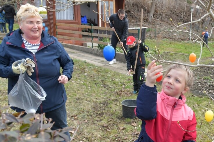 Sozialpädagogin Heike Lorenz ist zum Frühjahrsputz mit Kindern im "Grünen Klassenzimmer", einem Garten in der Anlage "Brüllender Löwe". Leonie (6) schmückt derweil einen Osterbaum. 