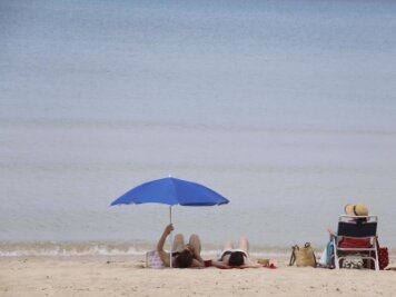 Spanien-Urlaub 2020: Sommer, Sonne, Strand und Schutzmaske -  
          Menschen sonnen sich am Strand von Arenal auf Mallorca. Bislang dürfen aber noch keine ausländischen Touristen nach Spanien.