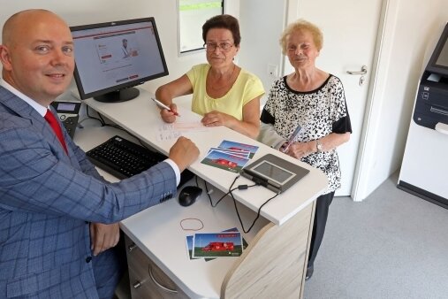 Sparkasse stellt mobile Geschäftsstelle vor - Unternehmenssprecher Sven Mücklich zeigt Gabriele Martin (links) und Lore Landgraf das neue Sparkassenmobil. 