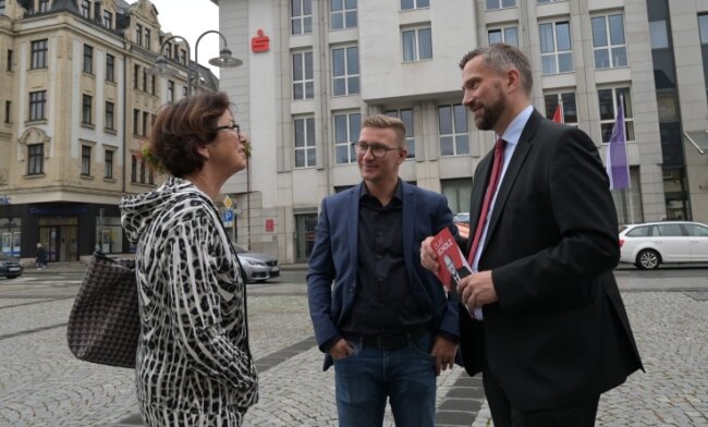 Silvio Heider (Mitte) und Martin Dulig im Gespräch mit Standbesucherin Monika Kampczyk auf dem Altmarkt in Aue. 