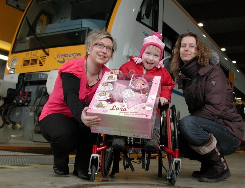 Spendenaktion für Hannah geht weiter - 
              <p class="artikelinhalt">Die auf den Rollstuhl angewiesene Hannah bekam heute neben der Geldspende von Sandy Eyring (l.) von der Freiberger Eisenbahn noch eine Puppe als Geschenk, worüber sich auch ihre Mutti freute. </p>
            
