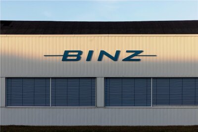 Spezialautohersteller Binz liefert erstmals in Plauen Fahrzeuge aus - Das Logo des Sonderfahrzeughersteller Binz auf einer Werkhalle wird von der Sonne angeleuchtet. Das Thüringer Unternehmen übernimmt das MAN-Werk im sächsischen Plauen. Der Betriebsübergang soll zum 1. April 2021 erfolgen. +++ dpa-Bildfunk +++