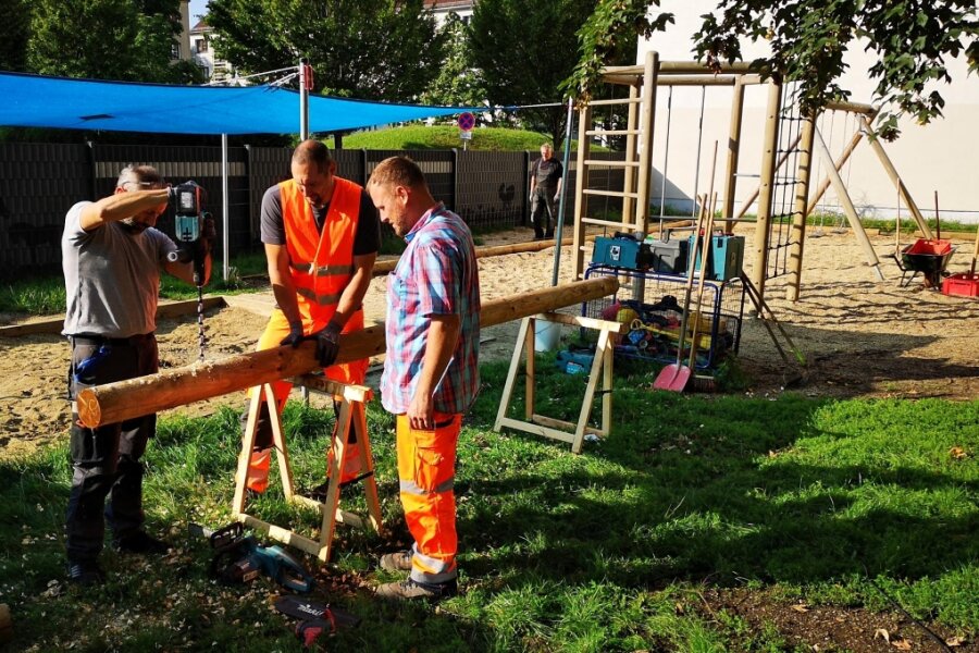 Spielplatz der Plauener Erich-Ohser-Grundschule vor der Fertigstellung - Handwerker vom Bauhof bauen derzeit zusammen mit Mitarbeitern der Straßenaufsicht die Holz-Umrahmung für den Fallschutz.