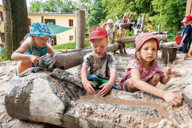 Spielplatz mit positiven Hintergedanken - In der christlichen Kindereinrichtung "Entdeckerland" in Schellenberg spielen Melissa, Gideon und Paula (v. l., alle vier Jahre alt) an ihrer eigens entworfenen Matschanlage im Garten.