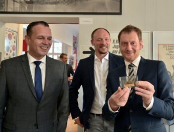 Sportmuseum "Saxosport" beeindruckt Michael Kretschmer - Michael Kretschmer, Marco Wanderwitz (m.) und der CDU-Landtagsabgeordnete Rico Anton (l.) mit einem Stück WM-Rasen von 1990. 