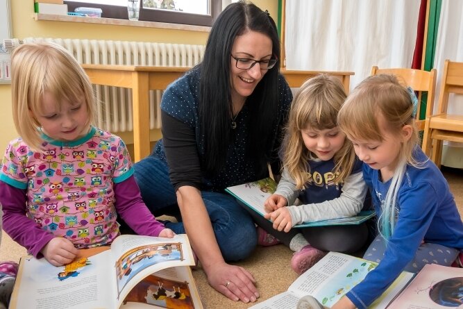 Tanja Skibbe lässt sich die Lieblingsbücher von fünf- bis sechsjährigen Kindern der Katzen-Gruppe zeigen. 