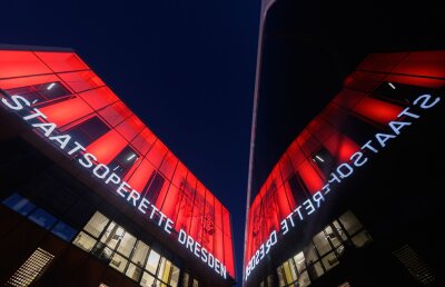 Staatsoperette Dresden: Fünf Premieren und neuer Musikchef - Die Fassade der Staatsoperette Dresden rot angestrahlt.