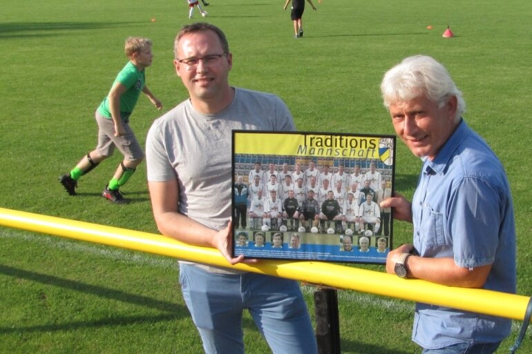 Heiko Blochwitz (l.) und Mike Leye zeigen ein Foto der Traditionsmannschaft des FC Carl Zeiss Jena, der Wolfgang Blochwitz lange Zeit angehörte. 