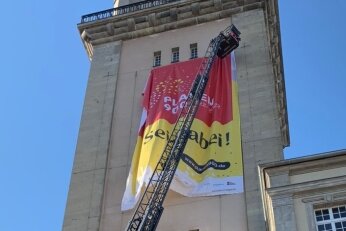 Stadtjubiläum: Laserprojektion am Plauener Rathaus verschoben - Am Rathausturm weist ein großes Banner auf das Plauener Jubiläum hin.