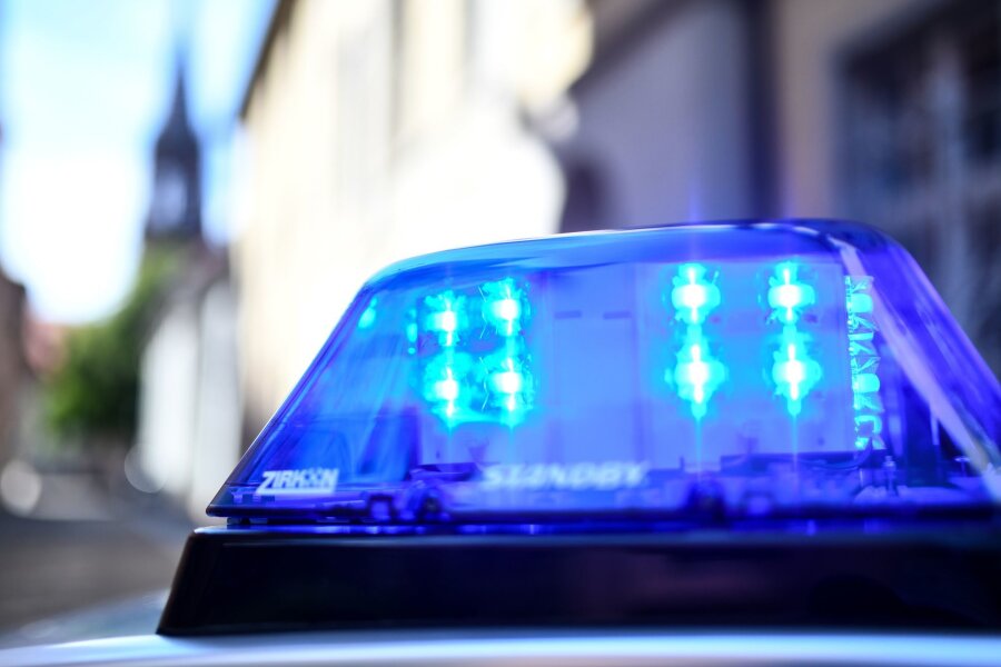 Steinwürfe auf Haus von Linken-Stadträtin: Emittlungen - Ein Polizeiauto mit blinkendem Blaulicht steht vor einem Gebäude.