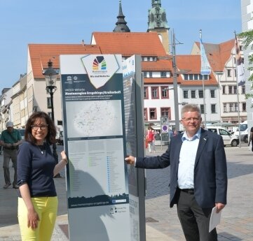 Stelen weisen Weg zum Welterbe - Anja Fiedler, Leiterin des Amtes Kultur-Stadt-Marketing, und Matthias Lißke, Geschäftsführer der Wirtschaftsförderung Erzgebirge, an der Stele am Obermarkt.