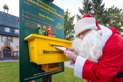 Sternemarkt und Wunschzettelbriefkasten: Weihnachtssaison in Seiffen eröffnet - Der Weihnachtsmann, verkörpert von Axel Wiedemann, hat seinen Wunschzettelbriefkasten wieder vor dem Seiffner Rathaus angebracht.