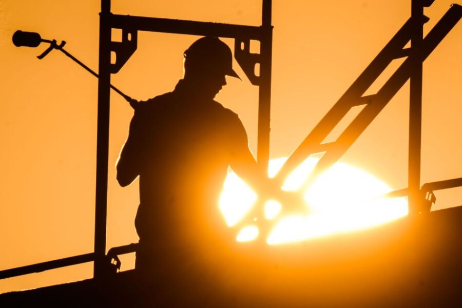 Stimmung im Handwerk "im Keller" - Ein Bauarbeiter mit einem Gasbrenner beim Bau eines Mehrfamilienhauses.