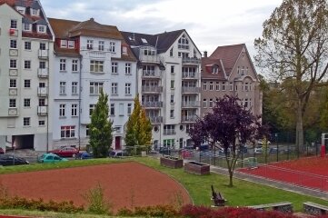 Die Teile der Aschenbahn auf der unteren Bildseite gehören zur Sportanlage der Plauener Friedens-Oberschule. Die Gebäude im Hintergrund stehen an der Scholtzestraße. 