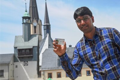 Streit über Abschiebung eines Pakistaners aus Burgstädt vorerst beigelegt - Der Pakistaner Muhammad Akram zeigt seinen Pass, der ihm ein Bleiberecht für drei Jahre in Deutschland gewährt. Der Bäckereigehilfe, vor der Bäckerei und der Stadtkirche in Burgstädt, sollte abgeschoben werden. 