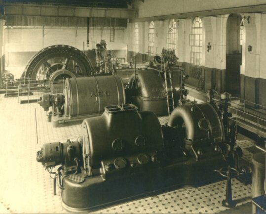 Blick in die Elektrozentrale des Vertrauenschachtes mit zwei Schwungradgeneratoren für die Stromerzeugung (im Hintergrund); vor 1917). 