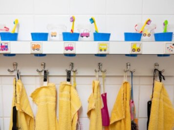            Handtücher und Zahnputzbecher hängen und stehen in einer Kindertagesstätte im Waschraum.
