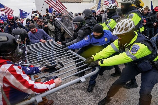 Demonstranten reißen am 6. Januar 2021 vor dem Kapitol in Washington eine Absperrung ein. Am Ende des Tages waren fünf Menschen tot. Insgesamt 140 Polizisten wurden verletzt. 