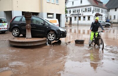 Süddeutschland ächzt unter dem Hochwasser - Auf einem Brunnen in Rudersberg steht ein durch Hochwasser weggespültes Auto.
