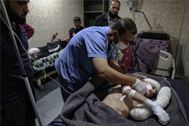 Syrienkrieg flammt wieder auf - Ein Sanitäter versorgt ein Kind, das in der syrischen Stadt Ariha bei einem Raketenbeschuss verletzt wurde. 