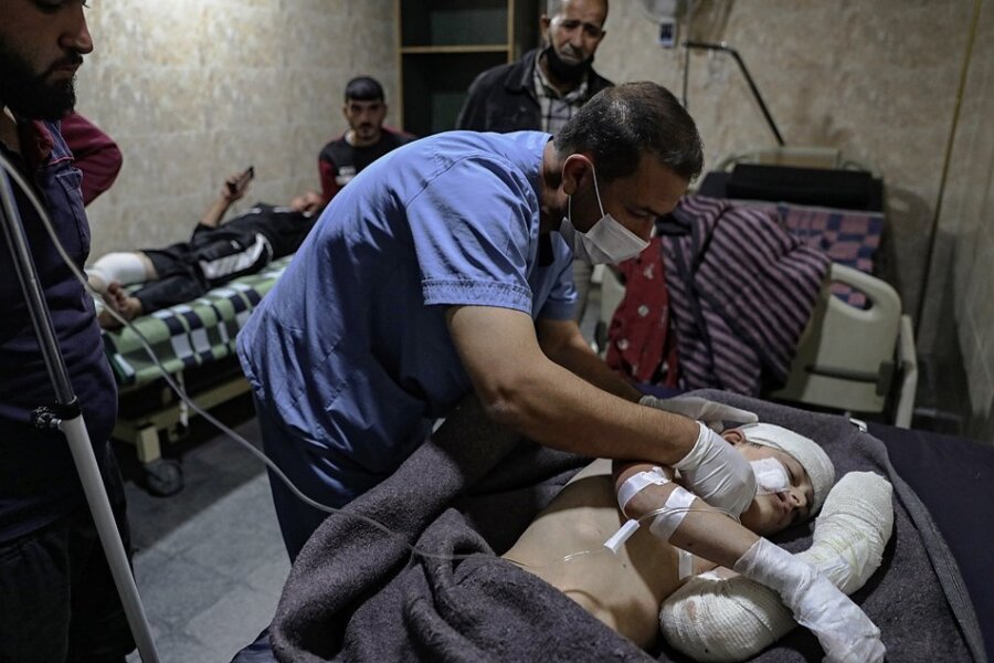 Ein Sanitäter versorgt ein Kind, das in der syrischen Stadt Ariha bei einem Raketenbeschuss verletzt wurde. 