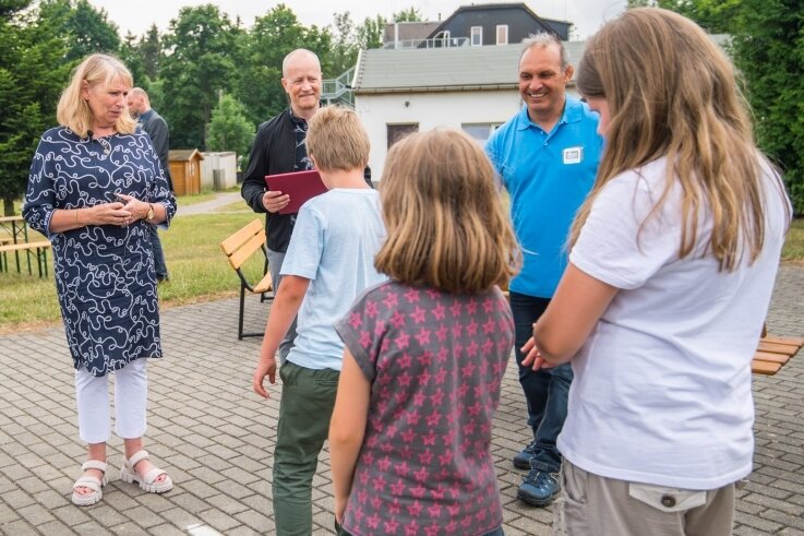 Mathias Hofmann, der Vorstand der Kindervereinigung Chemnitz (Mitte), und Sozialministerin Petra Köpping (links) beim Gespräch mit Schülern, die sich derzeit in der Tabakstanne aufhalten.