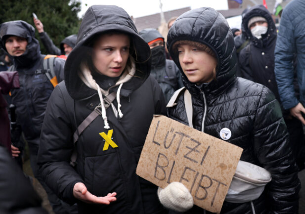 Erkelenz: Die Klimaaktivistinnen Luisa Neubauer (l) und Greta Thunberg nehmen an der Demonstration von Klimaaktivisten bei Lützerath unter dem Motto "Räumung verhindern! Für Klimagerechtigkeit" teil. Thunberg hält ein Schild mit der Aufschrift "Lützi bleibt".