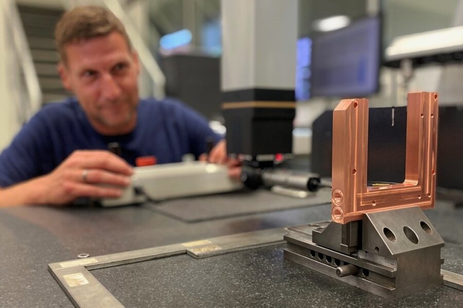 Technik, die Zahnarztbesuche erleichtert - Jens Melzer, Mitarbeiter in der Qualitätssicherung, beim Vermessen eines Kühlkörpers für die Lasertechnik. Das Bauteil besteht aus Kupfer. 