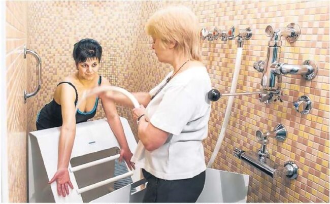 Teil 11: Kneipp-Therapie - Reizende Kälte - Bildtext: Das kalte Plätschern auf der Haut war für Cornelia Künzer (l.) aus Hoyerswerda zunächst ein kleiner Schock. Doch inzwischen genießt die 39-Jährige ihre Kneippschen Güsse bei Bademeisterin Annegret Herschel. Diese Form der Hydrotherapie gehört zur Behandlung, die sie während ihrer Reha in der Bad Schandauer Kirnitzschtalklinik verordnet bekommen hat. Die Kur wurde nach einer Wirbelsäulen-OP notwendig.