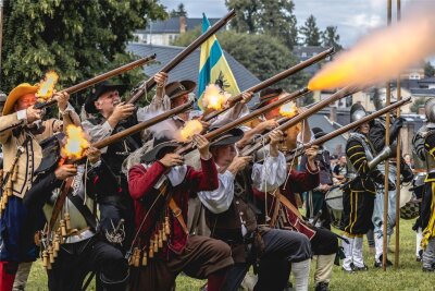 Teilnehmerrekord fordert die Gastgeber des Treuener Schlossfestes heraus - Die Geräuschkulisse ist gewaltig. Kanonen und Musketen entladen ihre Schwarzpulver-Fracht in Richtung Gegner.