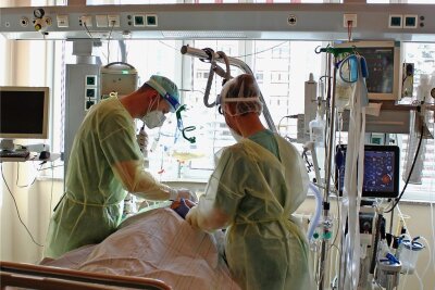 Teils nicht mehr aufnahmebereit: Angespannte Situation am Zwickauer Krankenhaus - Ein Arzt (links) und eine Pflegerin betreuen einen Patienten auf der Intensivstation im Heinrich-Braun-Klinikum. Dort wurden am Mittwoch 24 Covid-Infizierte behandelt. 