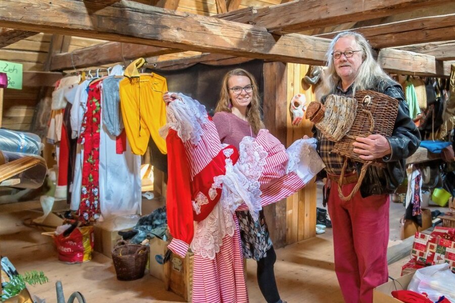 Theater Variabel in Olbernhau: Auf diesem Dachboden entsteht der Erfolg - Gunnar Rug und Juliane Röber inmitten der Requisiten und Kostüme. Er zeigt einen Drachenkopf aus Körben, sie ein Kleid. 