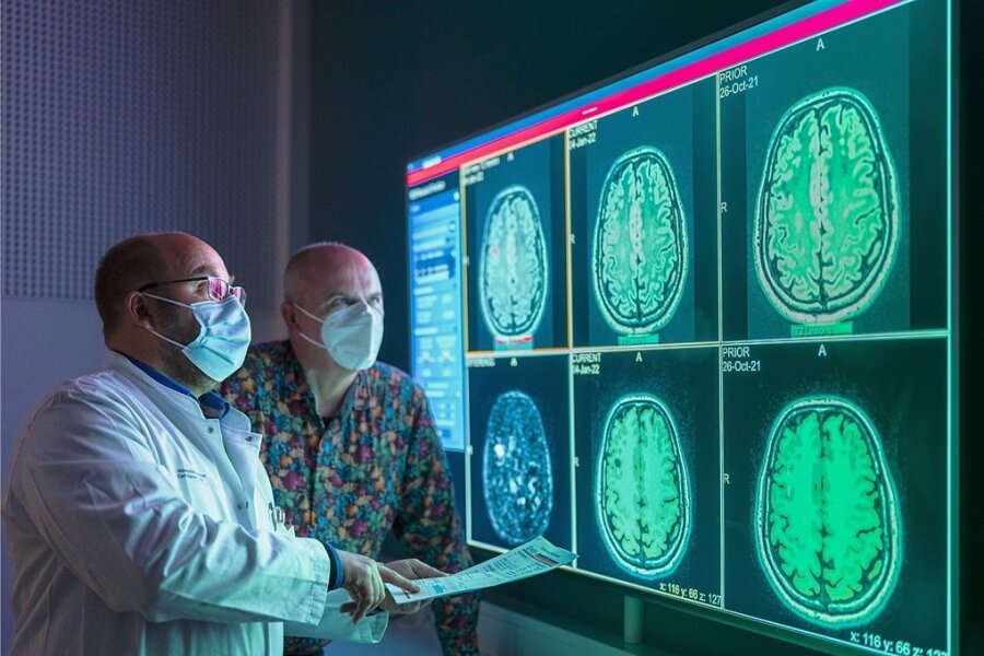 Patient Frank Borchard hat MS - Dr. Hagen Kitzler erklärt ihm am Uniklinikum Dresden anhand einer MRT-Aufnahme an einem Wandbildschirm die geschädigten Regionen in seinem Gehirn.