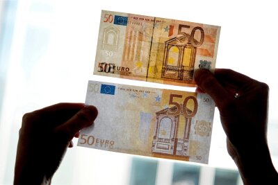 Tipps der Polizei: So erkennen Sie Falschgeld - Ein echter und ein falscher Fünfzig-Euro-Schein werden gegen das Licht gehalten. (Archiv)