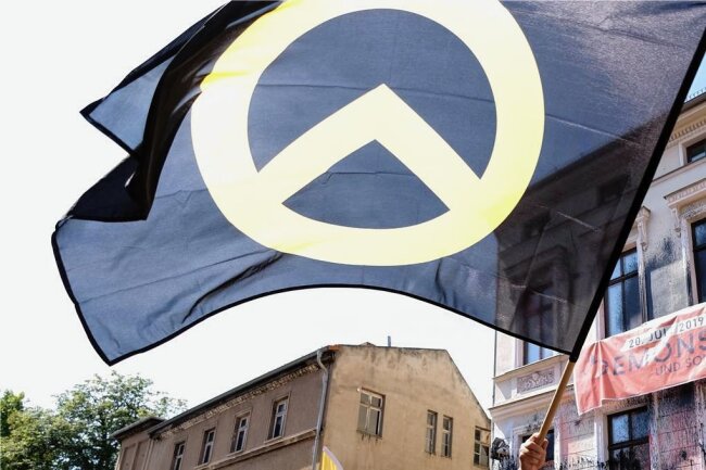 Tochtergesellschaft der Stadt Chemnitz: Kader einer rechtsextremen Gruppierung rückt in den Aufsichtsrat - Fahnen mit dem Symbol der Identitären Bewegung tauchen seit Jahren zunehmend auf Demonstrationen auf. Ein Aktivist der extrem rechten Gruppierung bestimmt in Chemnitz nun die Geschicke einer städtischen Gesellschaft mit.