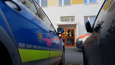 Toter Säugling in Plauener Wohnung gefunden - Einsatzkräfte am Eingang zum Wohnhaus an der Straße der Deutschen Einheit.