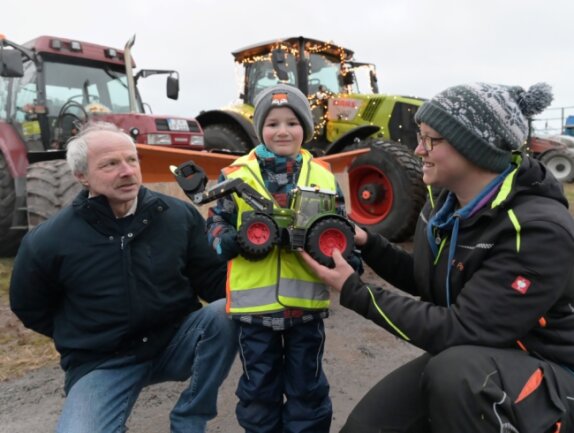 Henning Weinelt (Mitte) durfte mit seinem Opa Bernd Günther (li.) bei der Weihnachtstour der Traktoren dabei sein. Rechts Maria Pape, die zum Organisatoren-Team gehört.