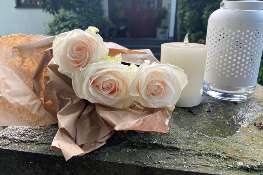 Trauer in Tirpersdorf nach Gewaltverbrechen: „Herr, erbarme dich dem jungen Mann“ - Trauernde legten Rosen am Haus der drei Getöteten in Tirpersdorf nieder und entzündeten Kerzen.