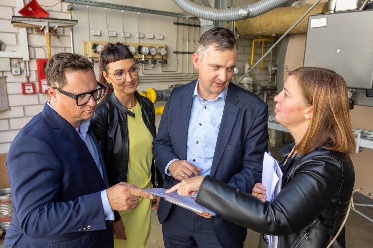 IHK-Präsident Hagen Sczepanski (links) und Bundestagsabgeordnete Yvonne Magwas (rechts) mit Mareen und Gregor Götz vor dem Gasbrenner. Dort wird Gas in heißes Thermalöl umgewandelt.