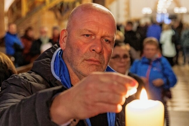 Unternehmer Torsten Köhler zündete nach der Friedensandacht in Sankt Annen eine Kerze an.