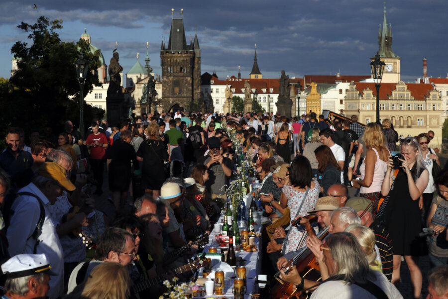 Tschechen nehmen die Maske ab - Festbankett auf Karlsbrücke - Anwohner sitzen zum Essen an einem 500 Meter langen Tisch auf der Karlsbrücke, nachdem die Einschränkungen gelockert wurden.
